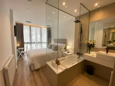 a bathroom with a bed and a tub and a sink at A PONTEVELLA Alojamiento Boutique, Sobradelo in Sobradelo