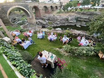 a group of people sitting around a table in the grass at A PONTEVELLA Alojamiento Boutique, Sobradelo in Sobradelo