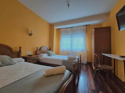 a hotel room with two beds and a window at Hostal Galicia in Monforte de Lemos