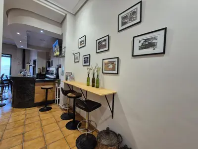 a room with a counter and a table with stools at Hostal Galicia in Monforte de Lemos