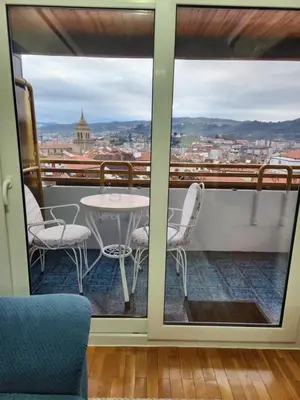 a balcony with a table and chairs and a view of the city at Estudio con vistas a la ciudad in Ourense