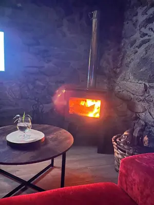 a living room with a table and a fireplace at ACASADOCRUCEIRO in Vales