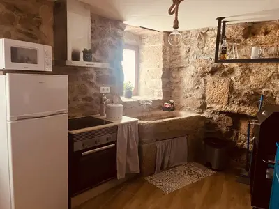 a kitchen with a white refrigerator and a sink at ACASADOCRUCEIRO in Vales