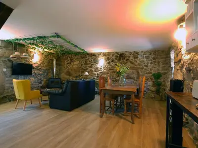 a living room with a table and yellow chairs at ACASADOCRUCEIRO in Vales