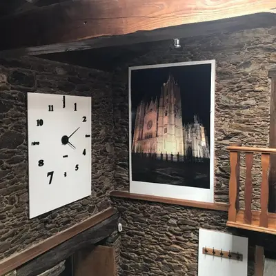 a clock and a picture on a wall at A Casacuberta in Marquiño