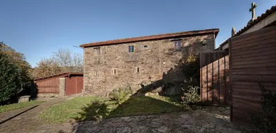 an old stone building with a fence in front of it at A Casacuberta in Marquiño