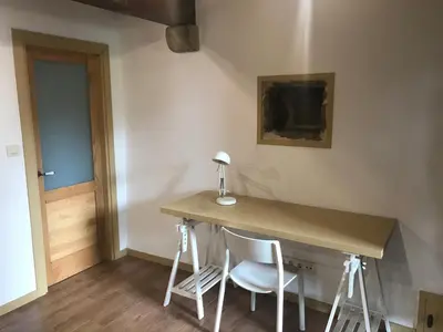 a desk in a room with two chairs and a lamp at A Casacuberta in Marquiño