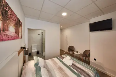 a bedroom with a bed and a painting on the wall at ALBERGUE SEGUE O CAMIÑO in Sigüeiro