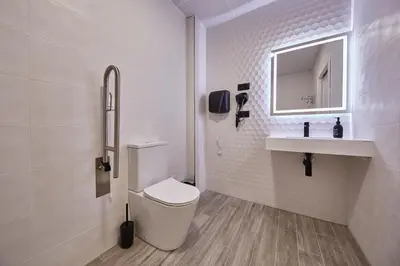 a bathroom with a toilet and a sink and a mirror at ALBERGUE SEGUE O CAMIÑO in Sigüeiro