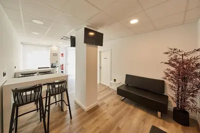 a kitchen with a counter and chairs in a room at ALBERGUE SEGUE O CAMIÑO in Sigüeiro