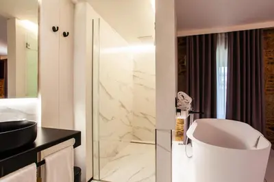 a bathroom with a tub and a toilet and a sink at Hotel Plaza Obradoiro by Bossh! Hotels in Santiago de Compostela