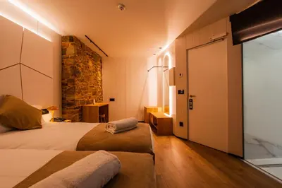 a hotel room with two beds and a door at Hotel Plaza Obradoiro by Bossh! Hotels in Santiago de Compostela