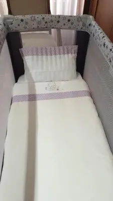 a bed with white sheets and purple pillows at Apartamento Cervantes in Ourense