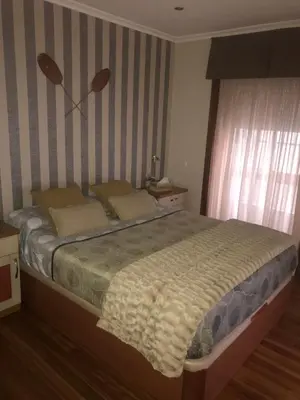 a bedroom with a bed with a striped wall at Apartamento Cervantes in Ourense