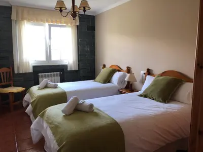 a hotel room with two beds and a window at Apartamentos Montemar in Navia