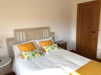a bedroom with a white bed with two pillows at Apartamentos Montemar in Navia