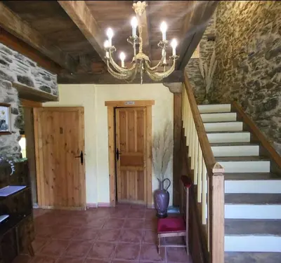 a hallway with a chandelier and stairs in a building at Hotel Rural LA CÁRCEL in Murias de Paredes
