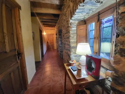 a hallway with a table with a tv on it at Hotel Rural LA CÁRCEL in Murias de Paredes