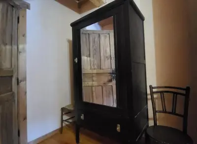 a black cabinet with a mirror in a room at Hotel Rural LA CÁRCEL in Murias de Paredes