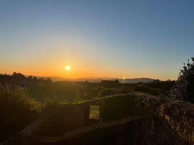 a sunset with the sun setting in the distance at A Casa do Portal, tu casa rural en Campo Lameiro, cerca de Pontevedra in Campo Lameiro