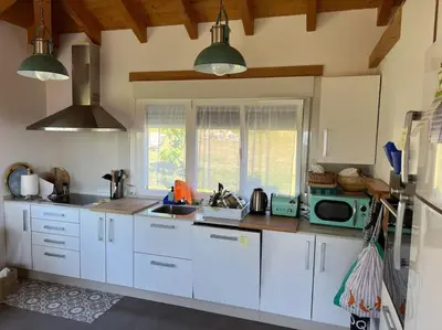 a kitchen with white cabinets and a microwave at A Casa do Portal, tu casa rural en Campo Lameiro, cerca de Pontevedra in Campo Lameiro
