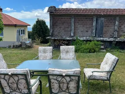 a table and four chairs in a yard at A Casa do Portal, tu casa rural en Campo Lameiro, cerca de Pontevedra in Campo Lameiro