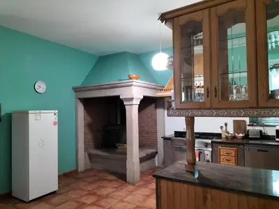 a kitchen with a stove and a white refrigerator at Casa Rural A Telleira in A Estrada