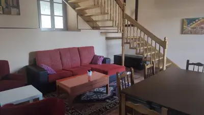 a living room with a couch and a table and stairs at Casa Rural A Telleira in A Estrada