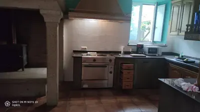 a kitchen with a stove and a sink and a window at Casa Rural A Telleira in A Estrada