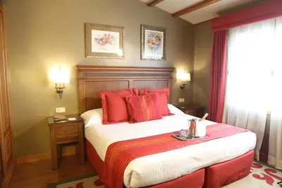 a bedroom with a large bed with red pillows at Gran Hotel Los Abetos in Santiago de Compostela