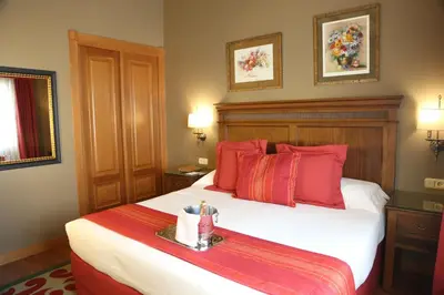 a bedroom with a large bed with red pillows at Gran Hotel Los Abetos in Santiago de Compostela