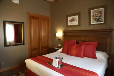 a hotel room with a bed with red pillows at Gran Hotel Los Abetos in Santiago de Compostela