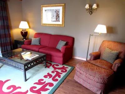 a living room with a red couch and a coffee table at Gran Hotel Los Abetos in Santiago de Compostela