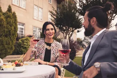 a man and a woman sitting at a table with wine glasses at Gran Hotel Los Abetos in Santiago de Compostela