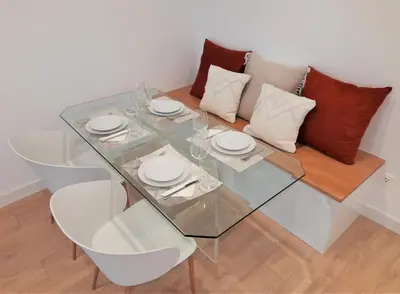 a glass table and chairs in a room with a couch at Apartamento con encanto en centro histórico Lugo -TineriaLucusHome in Lugo