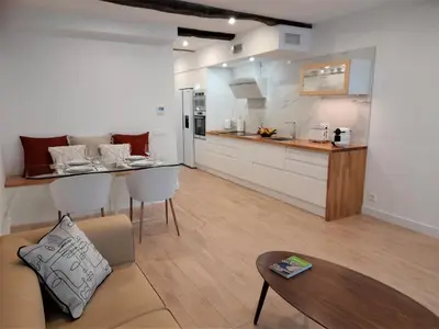 a kitchen and living room with a couch and a table at Apartamento con encanto en centro histórico Lugo -TineriaLucusHome in Lugo