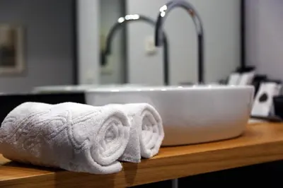 a bathroom sink with two towels on a counter at Hotel Alfonso IX in Sarria