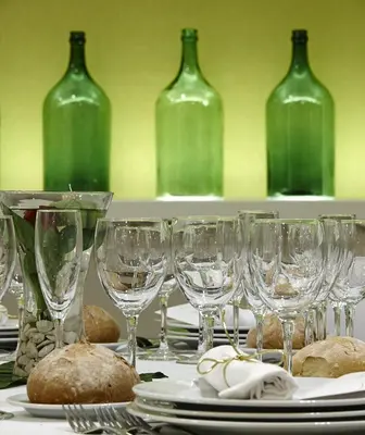 a table with wine glasses and plates and wine bottles at Hotel Alfonso IX in Sarria