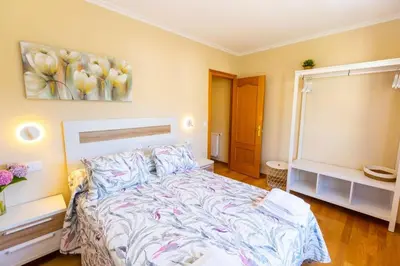a bedroom with a bed and a painting on the wall at APARTAMENTOS RIAMAR 2 in Ribadeo