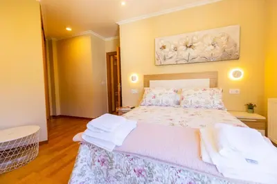 a bedroom with a bed and a painting on the wall at APARTAMENTOS RIAMAR 2 in Ribadeo