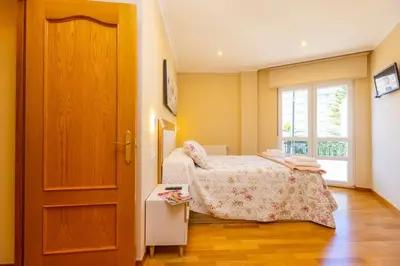 a small bedroom with a bed and a window at APARTAMENTOS RIAMAR 2 in Ribadeo