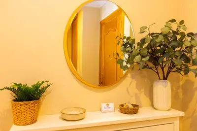 a bathroom with a mirror and a vase with a plant at APARTAMENTOS RIAMAR 2 in Ribadeo