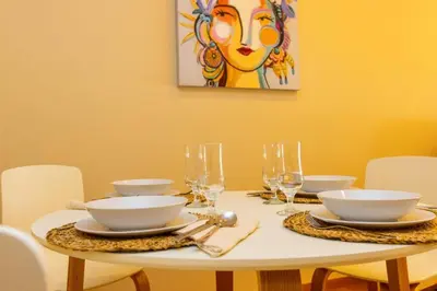 a table with plates and bowls and glasses on it at APARTAMENTOS RIAMAR 2 in Ribadeo