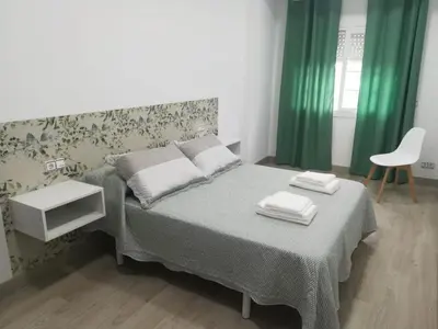a bedroom with a bed with green curtains and a chair at HORIZON in Arzúa