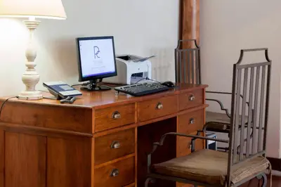 a wooden desk with a computer on top of it at Hotel Palacio del Carmen, Autograph Collection in Santiago de Compostela