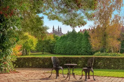 two chairs and a table in a park at Hotel Palacio del Carmen, Autograph Collection in Santiago de Compostela