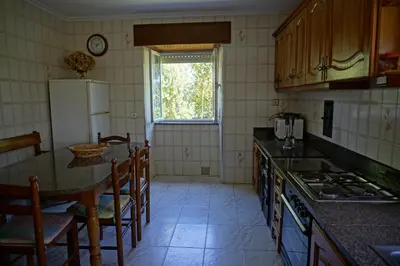 a kitchen with a refrigerator and a table and chairs at Casa Gayol in El Franco