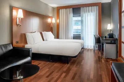 a hotel room with a white bed and a desk at AC Hotel Ponferrada by Marriott in Ponferrada