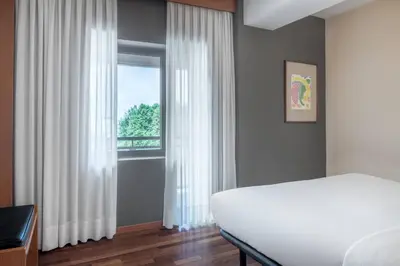 a bedroom with a white bed and a window at AC Hotel Ponferrada by Marriott in Ponferrada