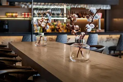 two vases with flowers in them sitting on a table at AC Hotel Ponferrada by Marriott in Ponferrada
